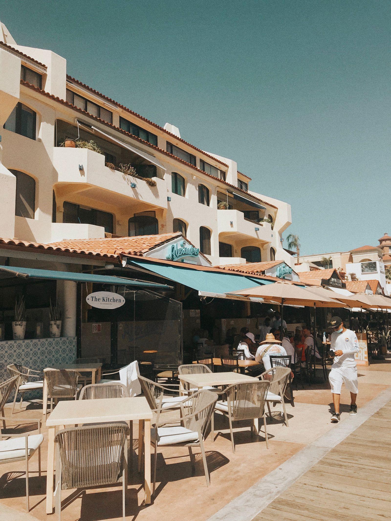 Diners relaxing at a sunlit outdoor restaurant patio in Cabo San Lucas