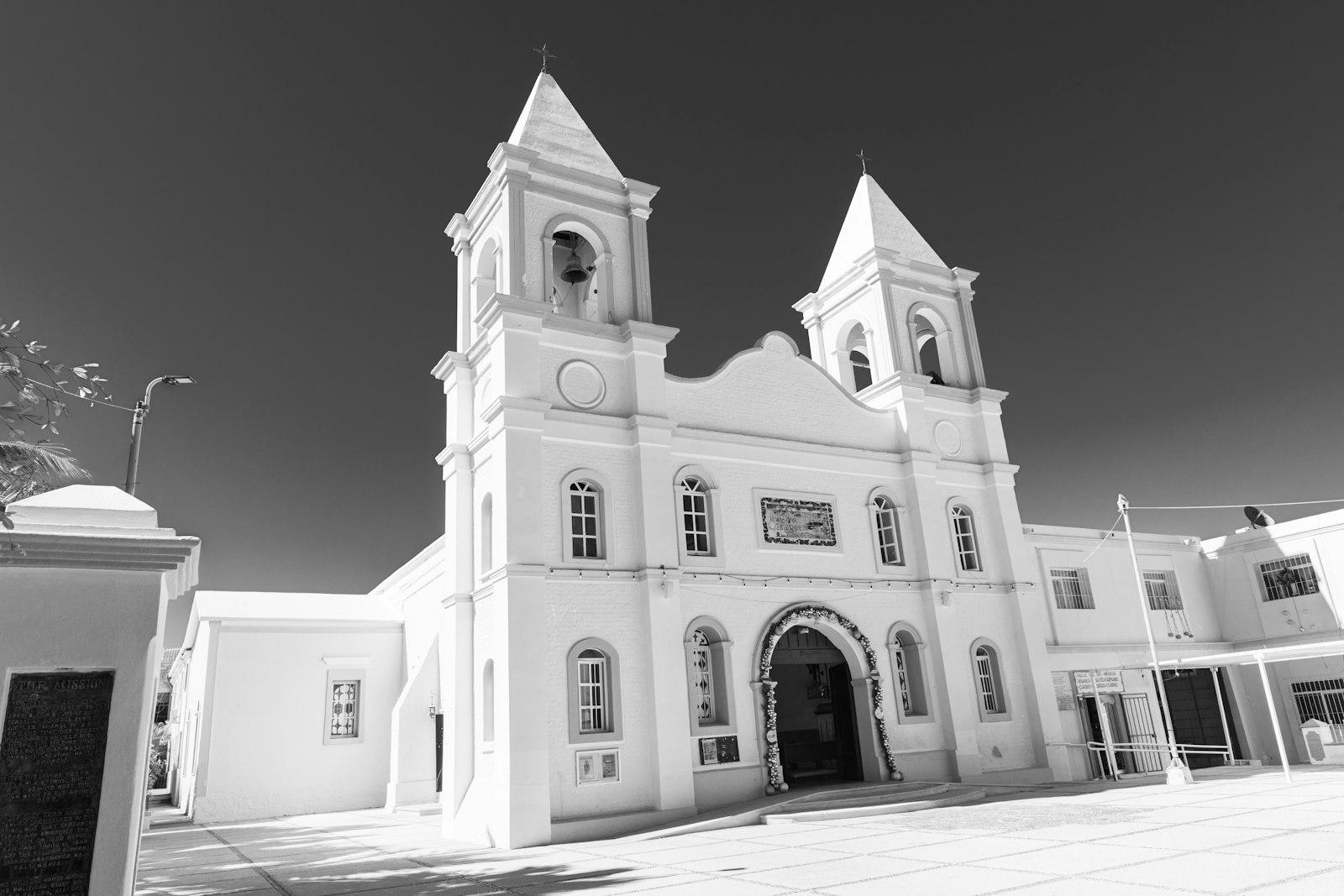 Twin bell towers and whitewashed facade of the Misión San José del Cabo, the church anchoring the plaza behind which the Art Walk gallery district runs.